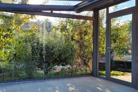 Sommergarten mit Glasschiebet&uuml;ren und einer Eingangst&uuml;r.